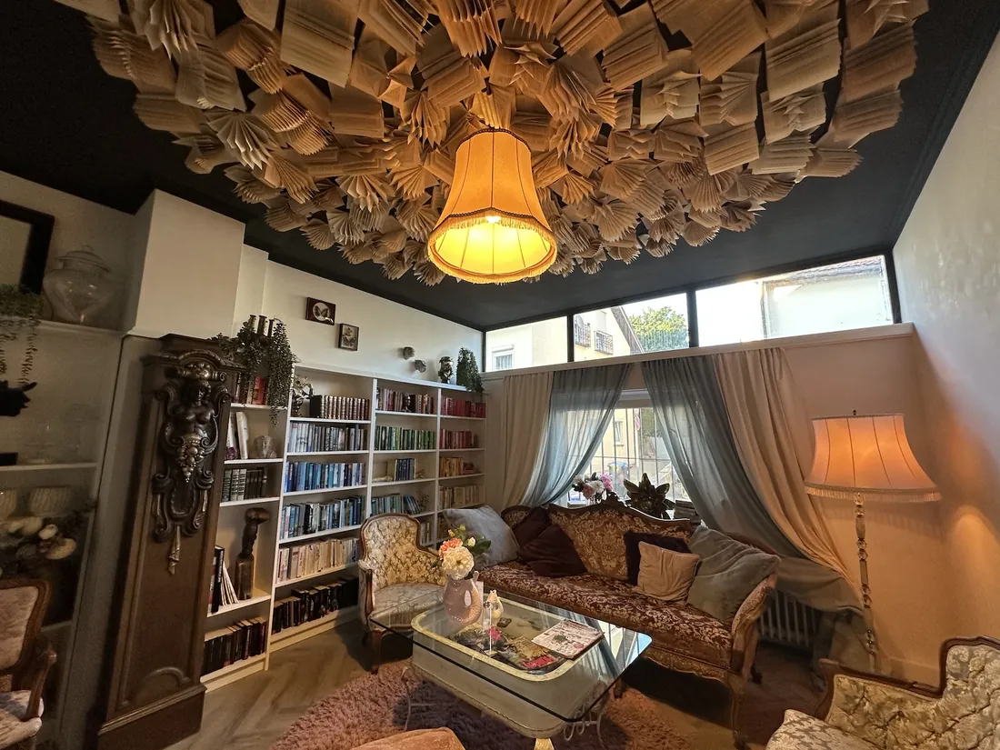 Der Leseraum mit Sofa, B&uuml;cherwand und warmem Lampenlicht